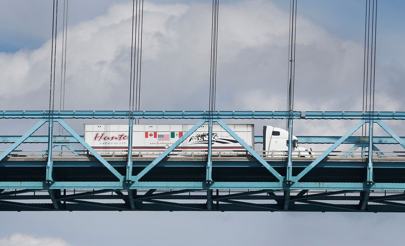 © Reuters. FILE PHOTO: A commercial truck with a Canada, United States and Mexico flag on its side is seen crossing over the Ambassador Bridge into Windsor, Ontario from Detroit,