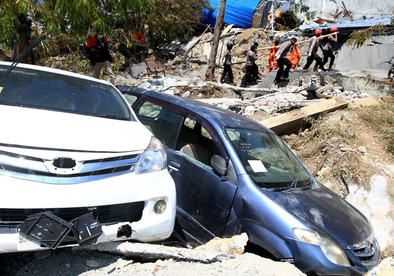 © Reuters. An Indonesian rescue team evacuates the body of a victim of an earthquake in Petabo, South Palu, Central Sulawesi