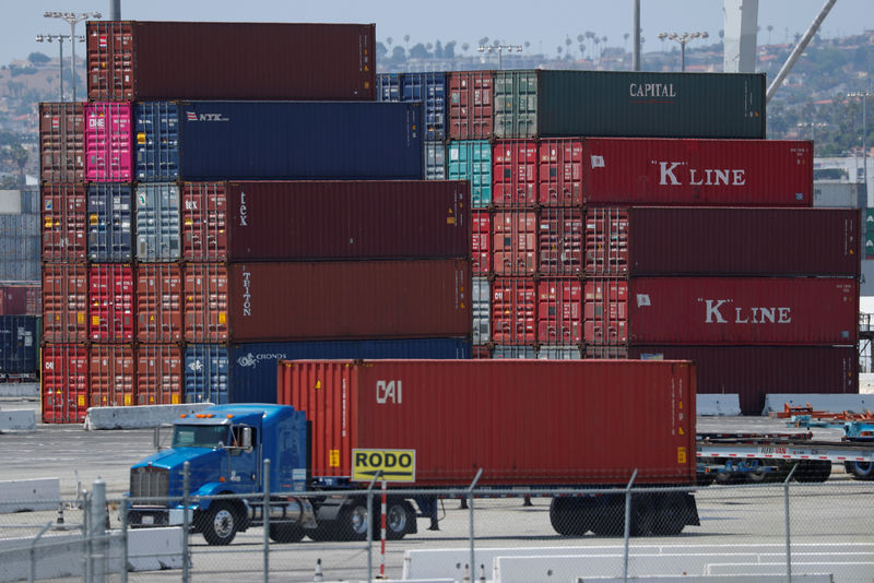 © Reuters. FILE PHOTO: Trucks offload containers from ship at the port of Los Angeles