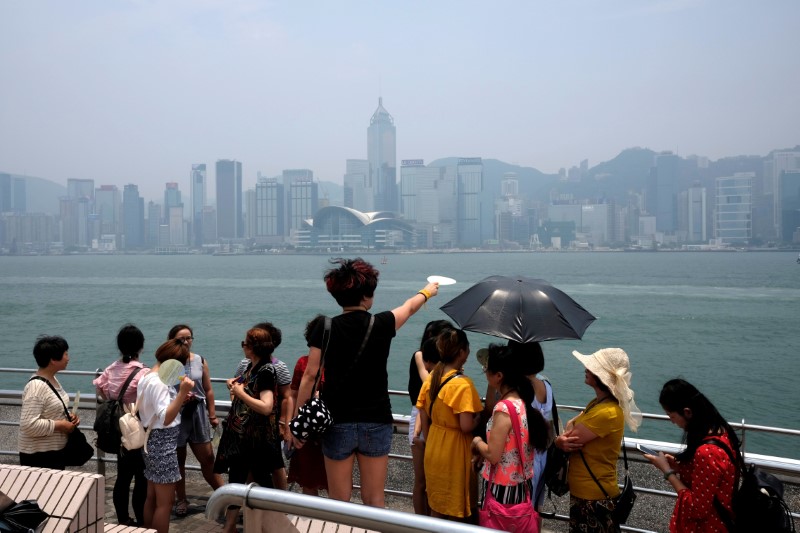 © Reuters. Mainland tourists admire the cityscape of Hong Kong