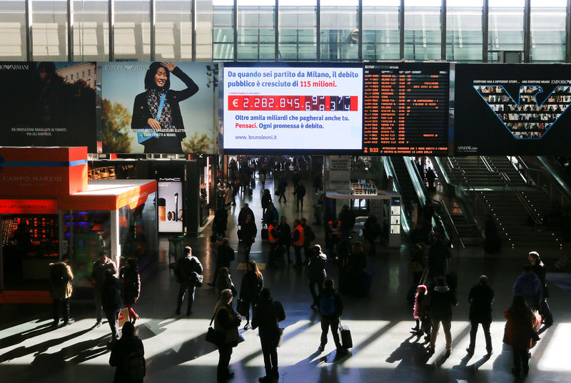 © Reuters. People walk past a "debt clock" screen displaying Italy's public debt in Rome