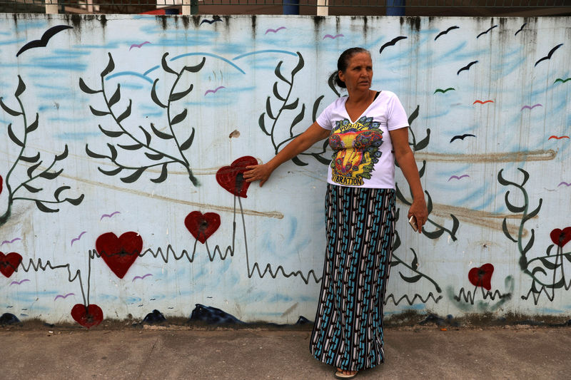 © Reuters. Rosilene Alves aponta para buracos de bala em muro da escola onde sua filha foi baleada em 2017, no Rio de Janeiro