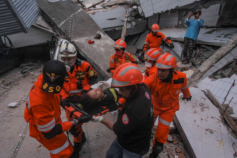 © Reuters. Search and rescue workers evacuate an earthquake and tsunami survivor trapped in a collapsed restaurant, Palu, Central Sulawesi