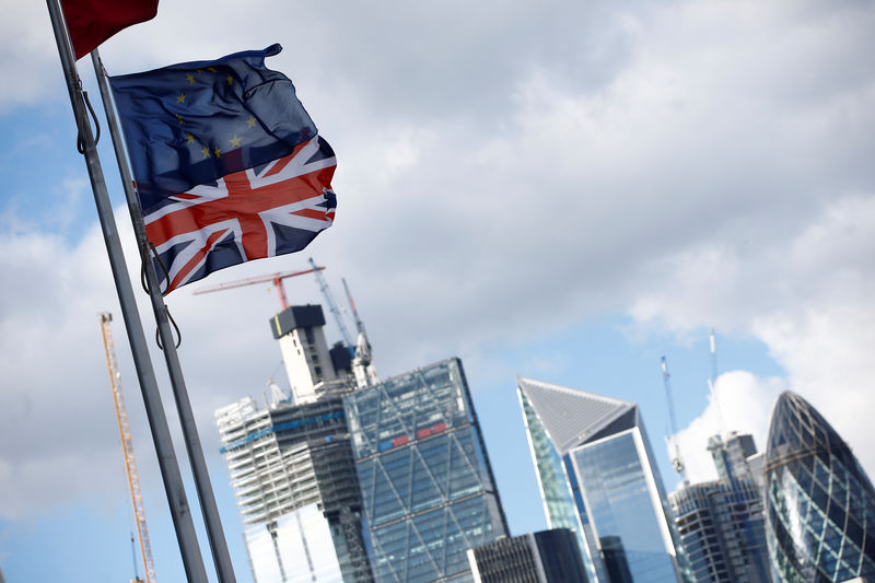 © Reuters. Flags flutter in the wind with the financial district in the background, in London