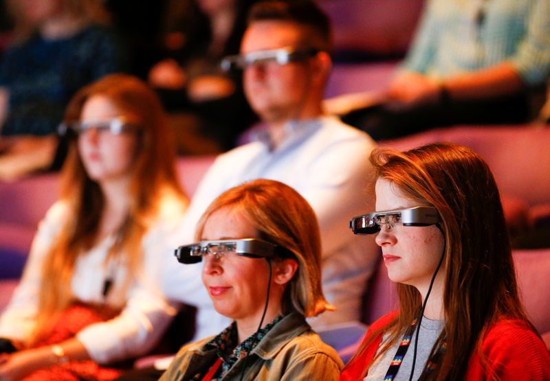 © Reuters. Gente observa una presentación en vivo de "El rey se muere" en el National Theatre mientras usan Smart Caption Glasses, diseñados por Epson, en Londres