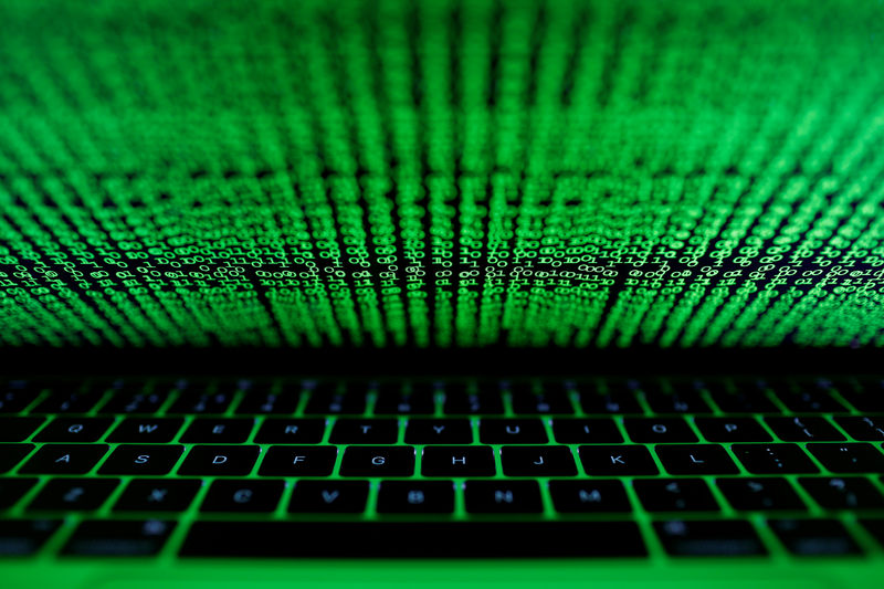 © Reuters. Ilustración fotográfica de código binario reflejado en la pantalla de un ordenador portátil