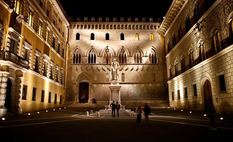 © Reuters. FILE PHOTO: People stand in front of Monte dei Paschi bank headquarters downtown Siena