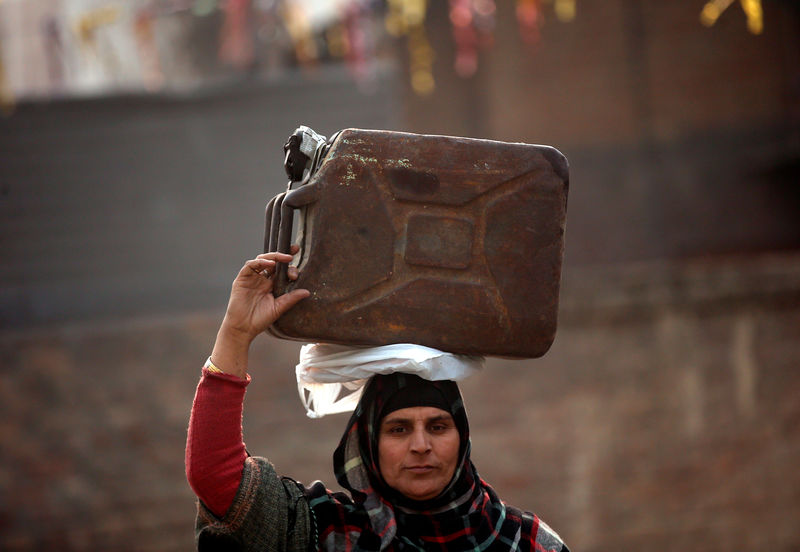 © Reuters. Женщина с канистрой керосина в окрестностях индийского города Сринагар