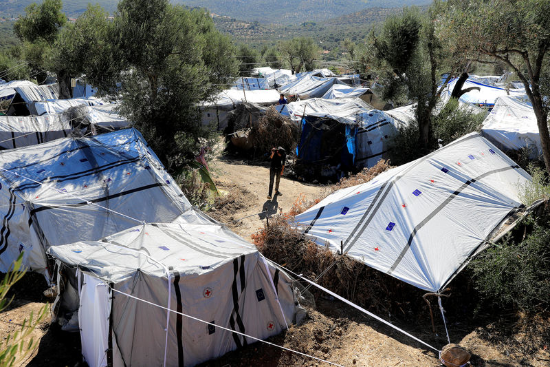 © Reuters. A migrant walks among tents at a makeshift camp next to the Moria camp for refugees and migrants on the island of Lesbos