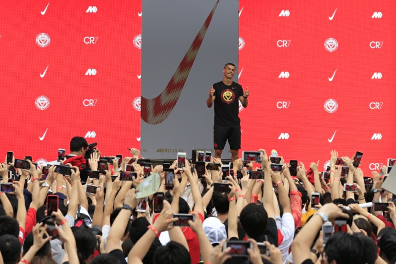 © Reuters. FILE PHOTO - Portuguese soccer player Cristiano Ronaldo gestures as fans take photos of him, during an event held by Nike for his annual CR7 Tour in Beijing
