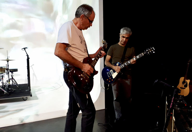 © Reuters. El británico David Jackson y el argentino Gabriel Sagastume tocan la guitarra durante un ensayo de la obra "Campo Minado" en Buenos Aires