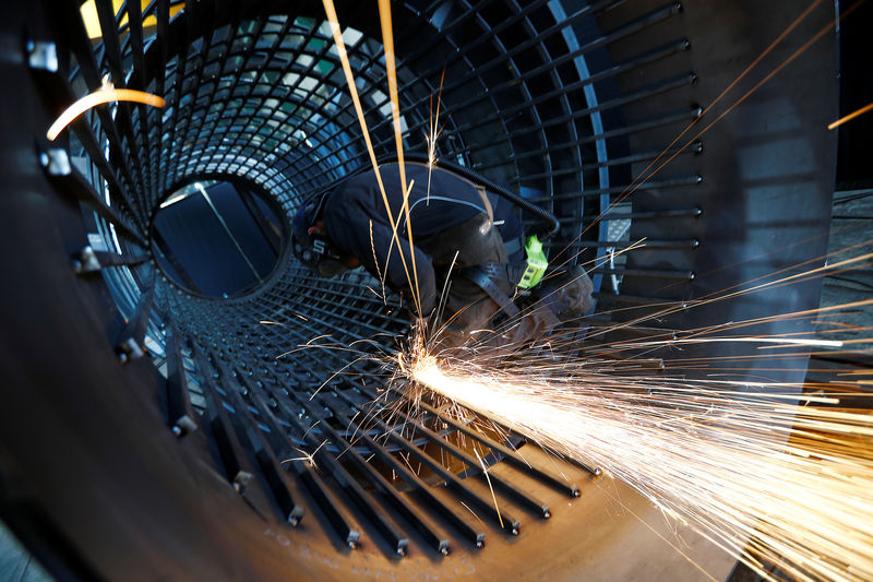 © Reuters. A worker grinds metal at the machine-building company Zemmler Siebanlagen in Massen