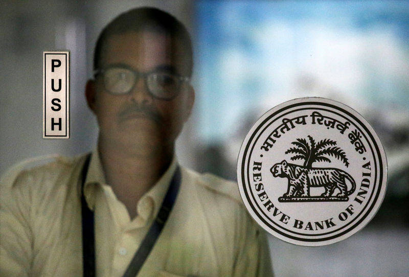 © Reuters. An employee walks behind the {{0|Reserve Bank of India}} (RBI) logo inside its headquarters in Mumbai