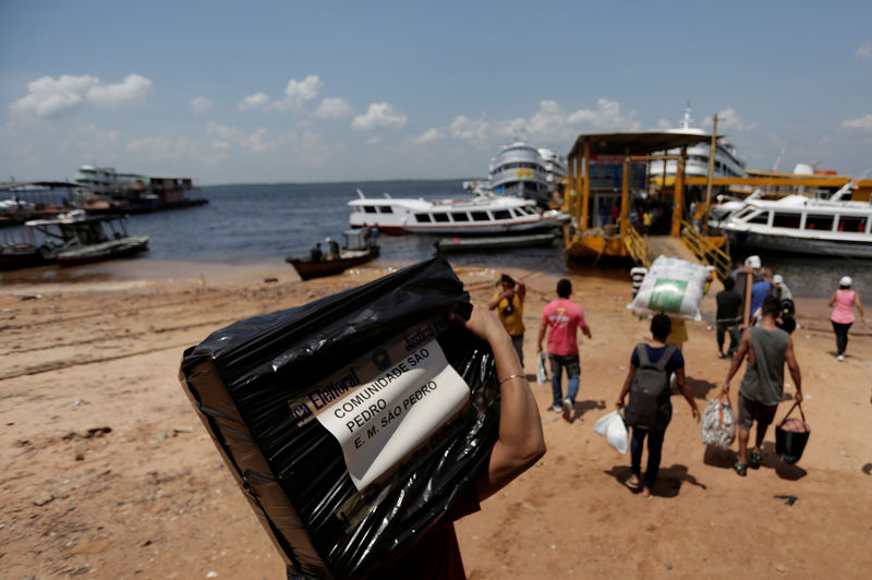 © Reuters. Funcionário da Justiça Eleitoral transporta urna para local de votação no Porto de Manaus