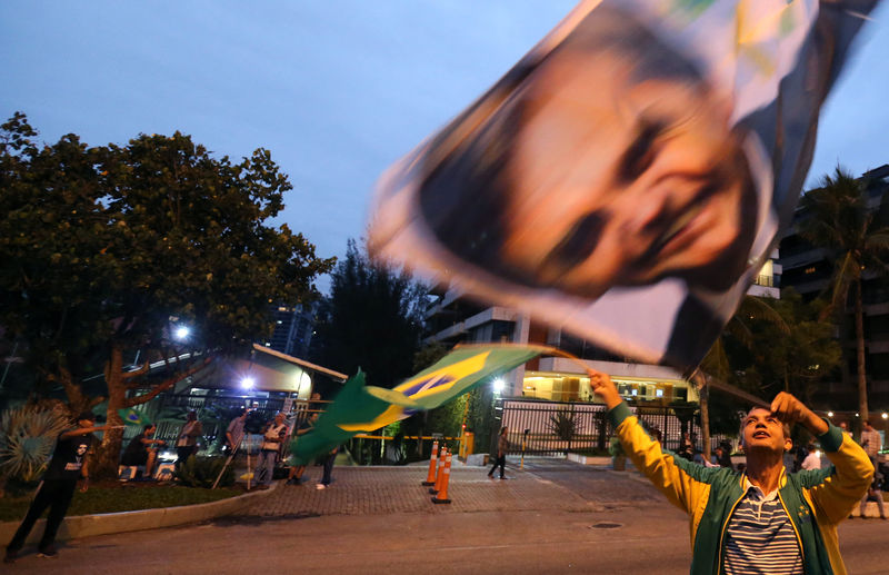 © Reuters. Un seguidor del candidato presidential ultraderechista brasileño Jair Bolsonaro anima a su líder junto al condominio en que vive en el barrio de Barra da Tijuca, en Río de Janeiro, Brasil.