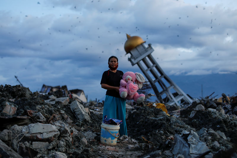 © Reuters. Mulher segura bicho de pelúcia encontrado nos destroços de sua casa em Palu, na Indonésia