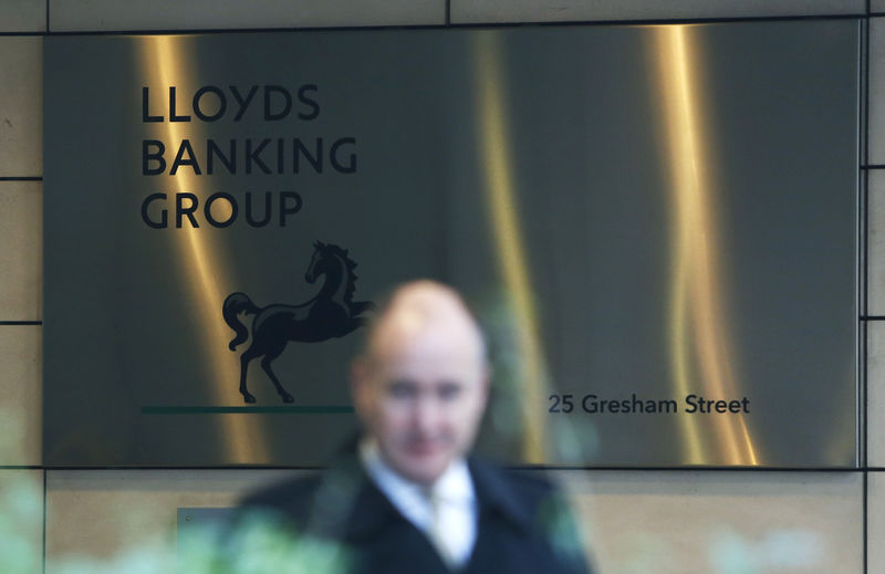 © Reuters. FILE PHOTO: A man walks past the entrance to the head office of Lloyds Banking Group in the City of London