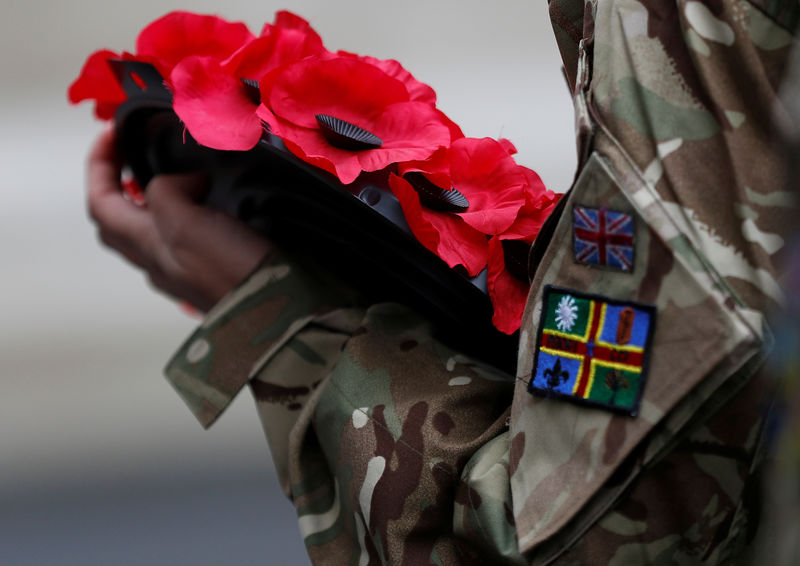 © Reuters. An army cadet holds a poppy wreath during the Western Front Association service at the Cenotaph to remember servicemen and women killed conflict, in London