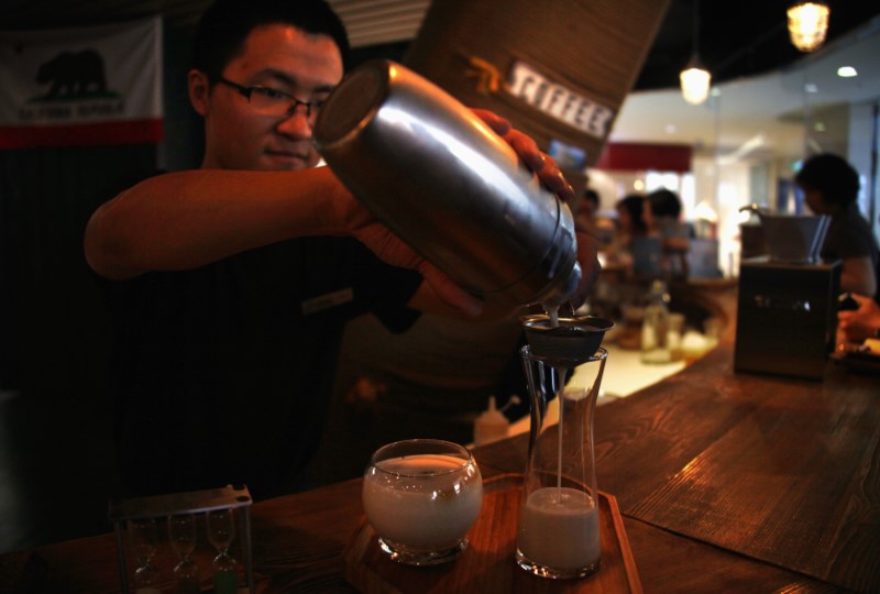 © Reuters. A waiter at a newly opened specialist coffee shop pours an iced-coffee drink for the members of a cupping (tasting) class in Beijing