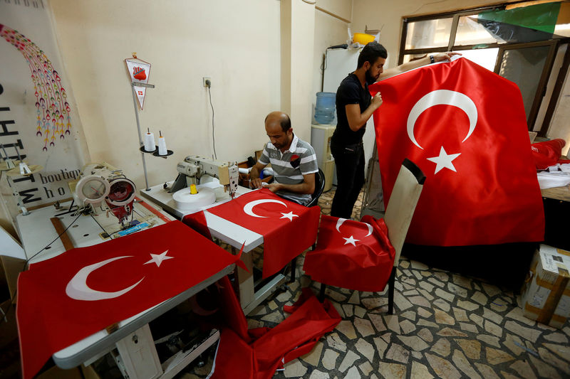 © Reuters. FILE PHOTO: Workers make Turkish flags at a small flag factory in Istanbul