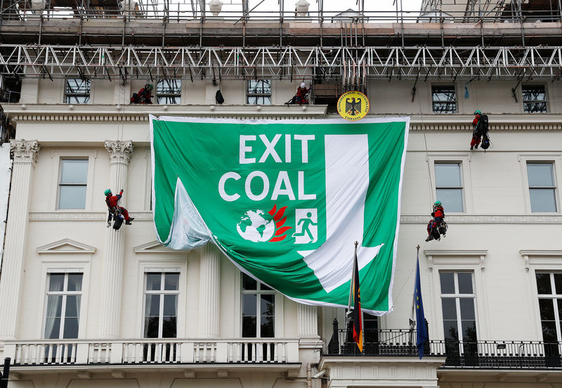 © Reuters. Greenpeace activists abseil down the facade of Germany's embassy as they unfurl a banner against coal, in London