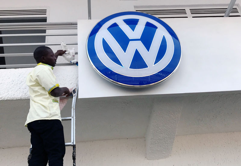 © Reuters. A worker fixes the Volkswagen logo outside the new car plant in Kigali