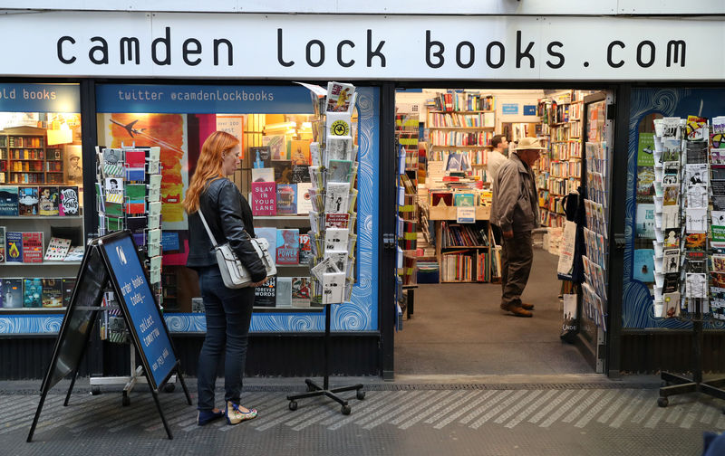 © Reuters. FILE PHOTO: A woman looks at gift cards outside Camden Lock Books shop, Old Street Station, London
