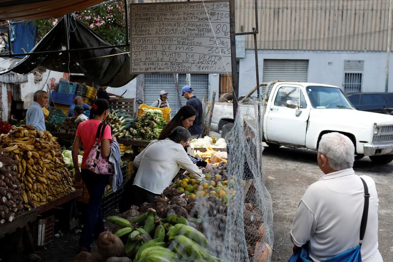 Â© Reuters. People shop at a vegetable and fruit stall at a street market in Caracas