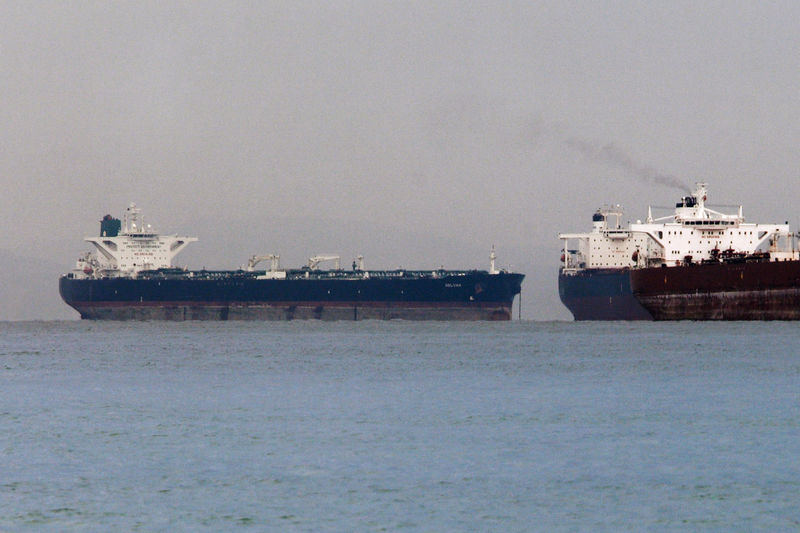 © Reuters. Vessels sail past Malta-flagged Iranian crude oil supertanker "Delvar" anchoring off Singapore