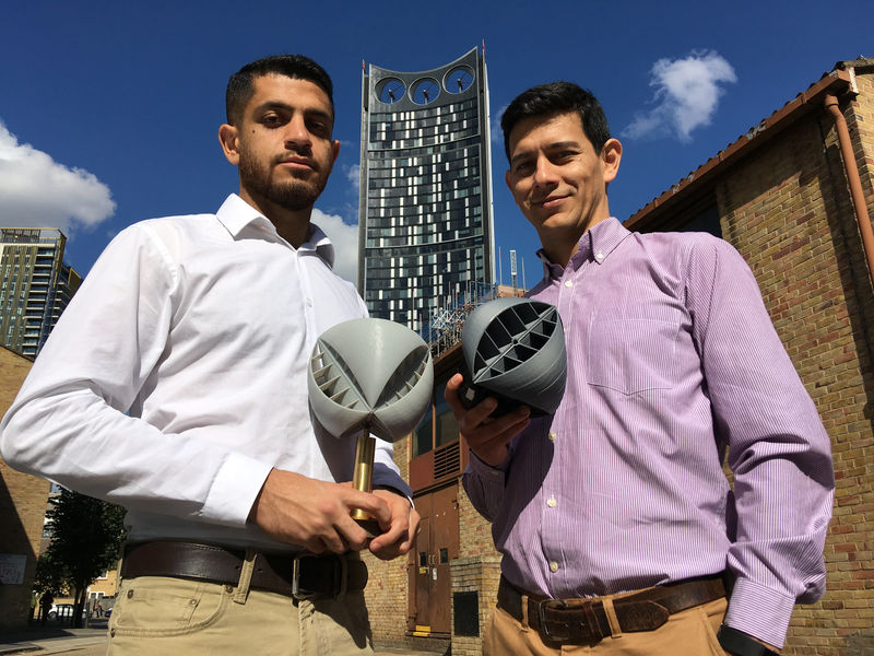 © Reuters. Lancaster University researchers Yaseen Noorani and Nicolas Orellana hold their O-Wind portable turbine prototype, for which they won the UK James Dyson Award, in front of the SE1 Strata building turbine in London