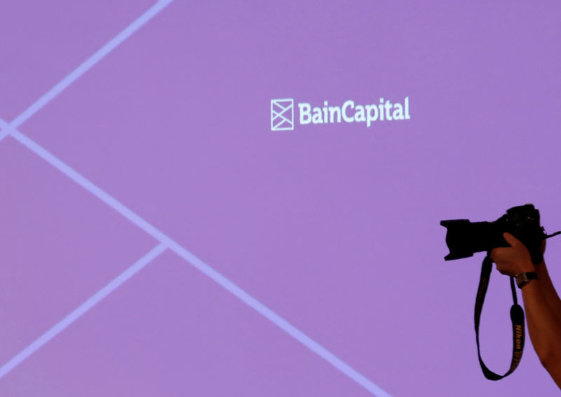 © Reuters. The logo of Bain Capital is displayed on the screen during a news conference in Tokyo