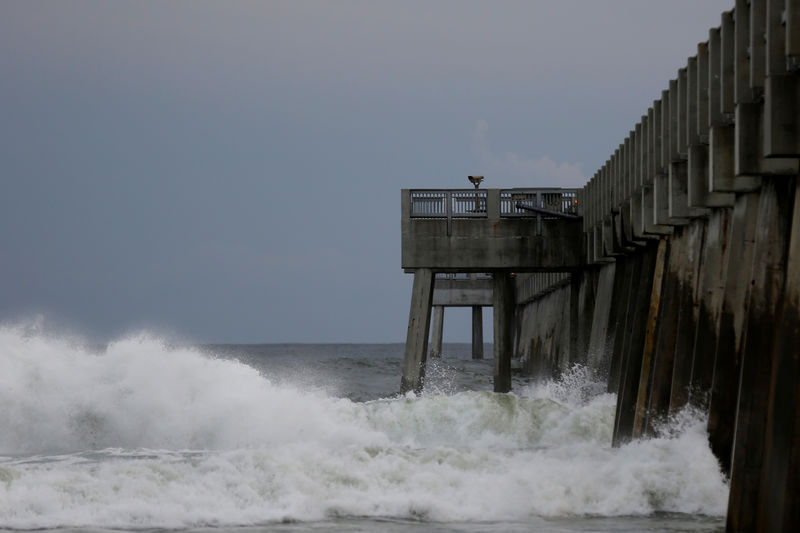 © Reuters. Волны разбиваются о пирс в Панама Сити Бич, штат Флорида, на фоне приближения урагана "Майкл"
