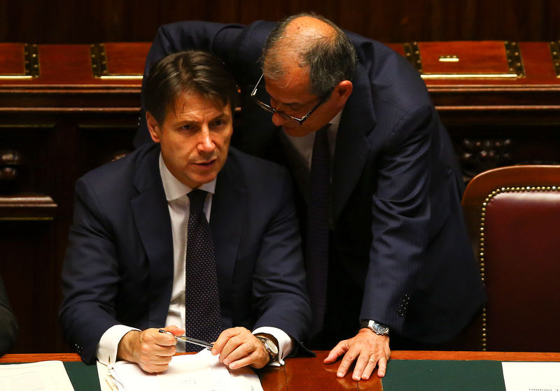 © Reuters. Italian Prime Minister Giuseppe Conte talks with Economy Minister Giovanni Tria during his first session at the Lower House of the Parliament in Rome