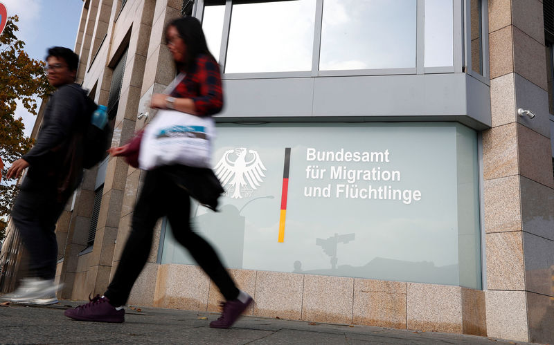 © Reuters. People walk in front of an office building of the Federal Office for Migration and Refugees in Berlin