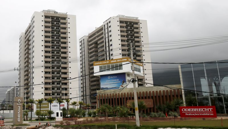 © Reuters. Buildings under construction are pictured next to a banner of Odebrecht SA at the Rio 2016 Olympic Games athletes village in Rio de Janeiro