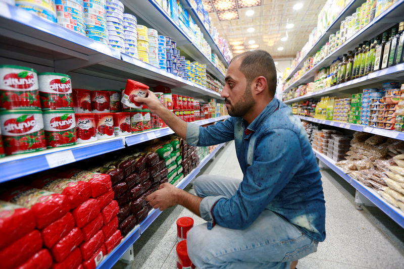 © Reuters. A shop worker arranges the cans of Iranian tomato paste at a super market in the city of Najaf