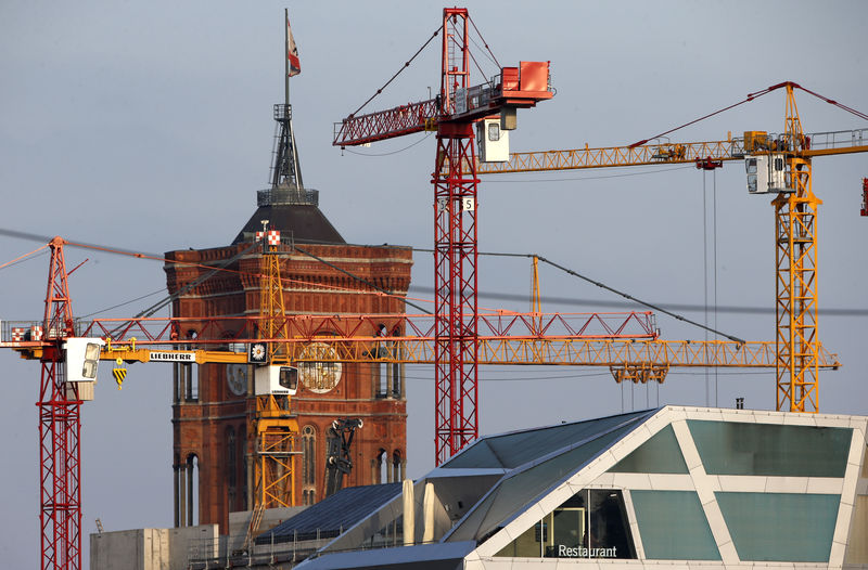 © Reuters. Construction cranes are pictured beside the tower of the Red City Hall in Berlin