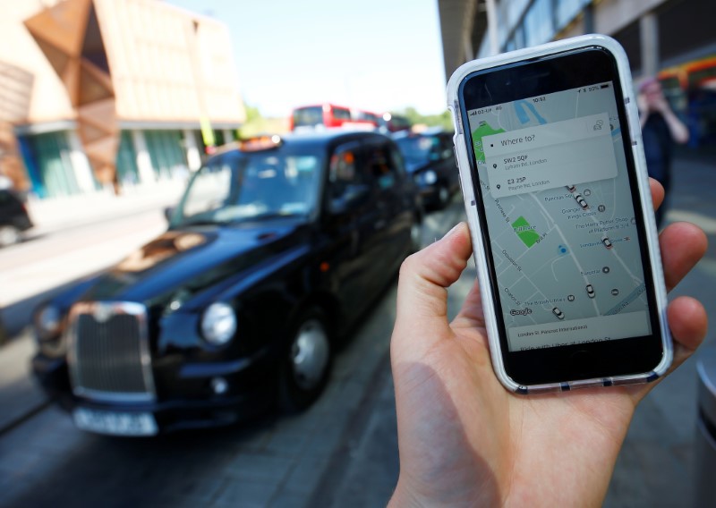 © Reuters. A photo illustration shows the Uber app on the mobile phone and a black cab in London