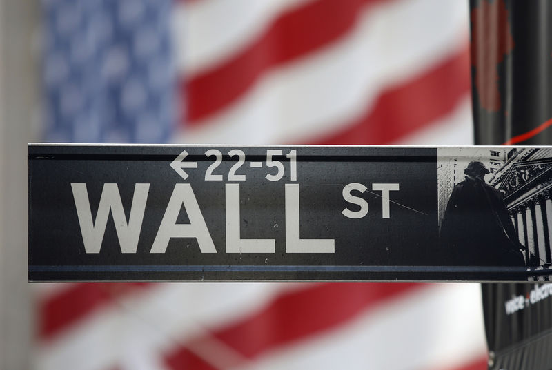 © Reuters. A sign for Wall Street is seen with a giant American flag in the background across from the New York Stock Exchange