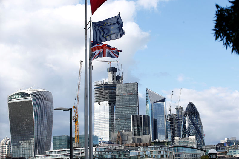 © Reuters. FILE PHOTO: Flags flutter in the wind with the financial district in the background, in London