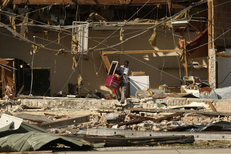 © Reuters. 13-year-old Kaleb Cassel removes belongings from a flea market damaged by Hurricane Michael in Panama City