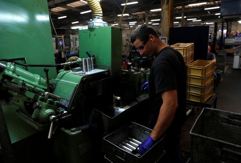 © Reuters. FILE PHOTO: A worker holds a component for a Volvo truck at the Muller manufacturing facility in Redditch