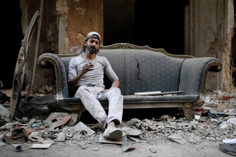 © Reuters. في مخيم اليرموك بسوريا .. فلسطيني لا يعبأ بالحرب لتربية الحمام