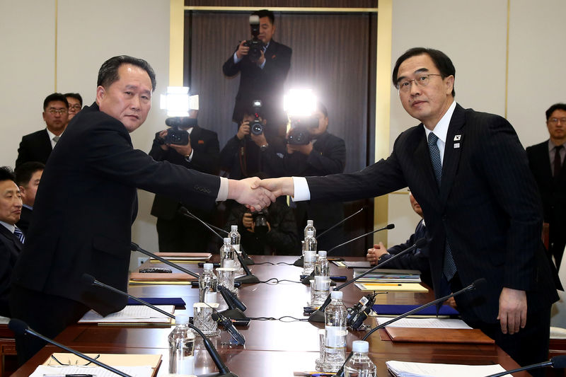 © Reuters. FILE PHOTO: Head of the North Korean delegation, Ri Son Gwon shakes hands with South Korean counterpart Cho Myoung-gyon as they exchange documents after their meeting at the truce village of Panmunjom