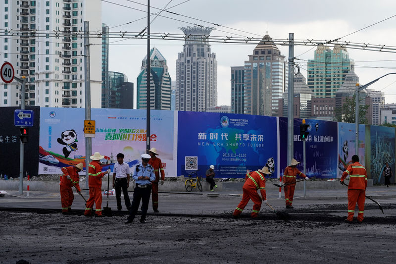 © Reuters. Workers pave a road ahead of the China International Import Expo in Shanghai