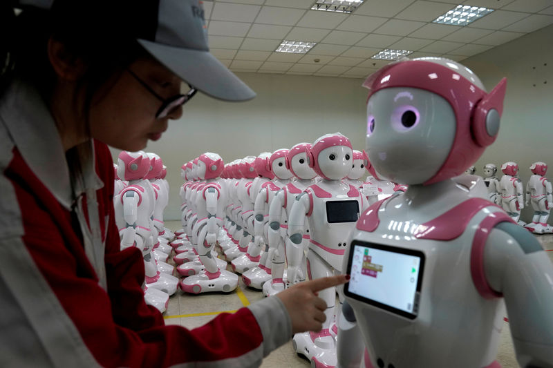 © Reuters. FILE PHOTO: A worker puts finishing touches to an iPal social robot, designed by AvatarMind, at an assembly plant in Suzhou
