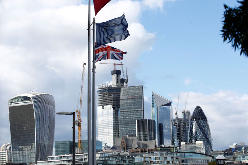 © Reuters. Flags flutter in the wind with the financial district in the background, in London