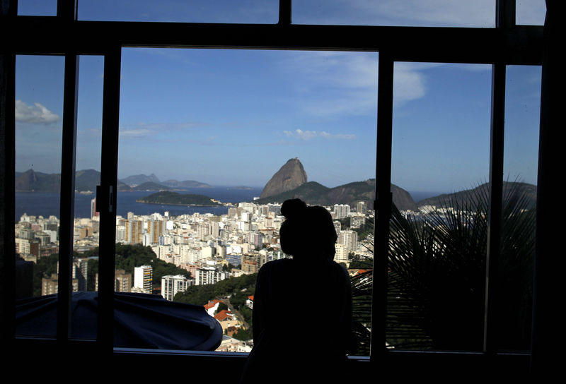© Reuters. French student Melodie Valerio looks out the window of her rented room in the Pereira da Silva slum in Rio de Janeiro