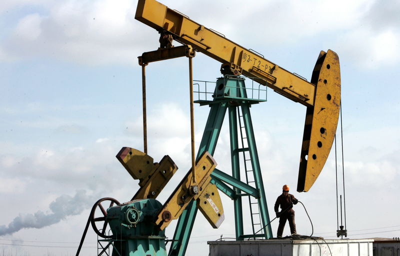 © Reuters. FILE PHOTO - A Chinese man works at a pump jack in PetroChina's Daqing oil field in China's northeastern Heilongj..