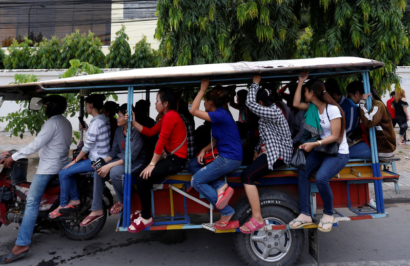 © Reuters. Garment workers travel back home as they leave a factory after work, on the outskirts of Phnom Penh